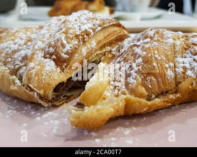 Délicieux croissant français avec remplissage au chocolat et sucre en poudre sur le dessus Banque D'Images