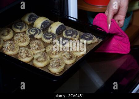 Une femme met au four des curligues farcies de pavot et de noix. Pour la cuisson. Banque D'Images