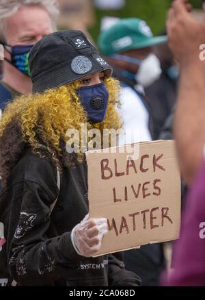 Une femme protestante, aux cheveux jaunes, portant un masque et un chapeau tient un panneau « BLACK LIVES Protest » au London Hyde Park Protest. ROYAUME-UNI Banque D'Images