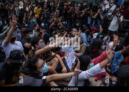 Bangkok, Thaïlande. 3 août 2020. Les manifestants pro-démocratie saluent à trois doigts - un symbole adopté par les manifestants thaïlandais lors des Jeux de la faim - s'assoient sur le trottoir en face du monument de la démocratie lors d'une manifestation sur le thème de Harry Potter à Bangkok, en Thaïlande, le lundi 3 août 2020. La manifestation pro-démocratie a été intitulée « Castagner le charme de Patronus pour protéger la démocratie », dans le cadre d'une série de manifestations au cours des dernières semaines. Les manifestations ont cessé depuis février en raison de l'épidémie de COVID-19, mais la Thaïlande n'a enregistré aucune nouvelle transmission locale en plus de deux mois et le pro-démocrate Banque D'Images