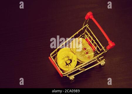Pièces de monnaie en bitcoin dans le panier. Arrière-plan noir Banque D'Images