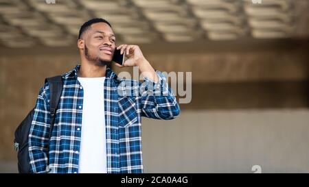 Homme noir debout en ville parlant au téléphone Banque D'Images