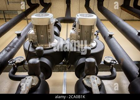 Système de chauffage central dans un bâtiment industriel, avec tuyaux isolés, vannes manuelles et pompes Banque D'Images