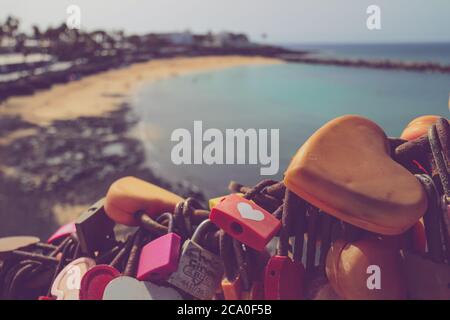 Locks d'amour en forme de coeur attachés à des chaînes à un point de vue surplombant la plage Playa Flamingo à Playa Blanca, Lanzarote. Banque D'Images