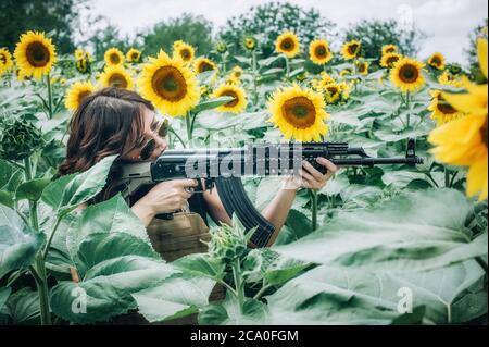Belle et attrayante femme soldat avec mitraillette à fusil. Femme armée nature entraînement militaire de combat en plein air. Femme fatale Banque D'Images