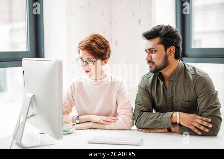 Deux collègues de sexe masculin ont surpris la lecture de nouvelles sur ordinateur au bureau Banque D'Images