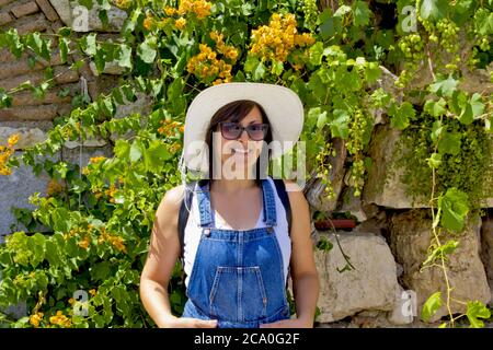 Belle jeune femme en chapeau blanc marchant dans le parc Banque D'Images