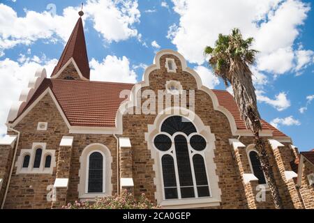 Façade latérale vue de l'église du Christ (Christuskirche) sous un ciel bleu avec des nuages moody à Windhoek, Namibie Banque D'Images