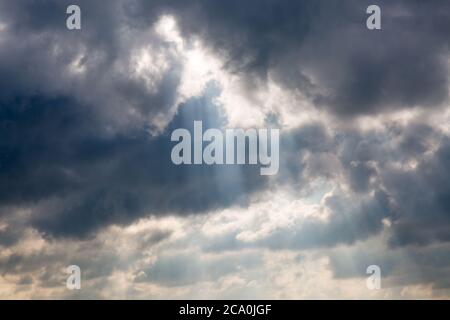 Une photo plein cadre de rayons de soleil qui brillent à travers les nuages de tempête Banque D'Images
