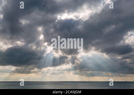 Poutres de soleil qui brillent à travers les nuages au-dessus de la mer, à Brighton Banque D'Images