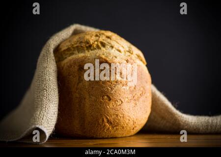 pain fait maison cuit à partir d'une machine à pain sur fond noir Banque D'Images
