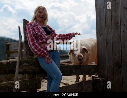 fille gaie sur un ranch écologique avec cochon Banque D'Images