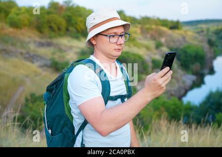 le gars regarde la navigation de carte dans le téléphone pendant les déplacements Banque D'Images