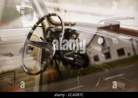 intérieur d'une vieille voiture allemande d'un trabbi oriental avec volant et extincteur dans le cockpit et clés accrochent dans la serrure Banque D'Images