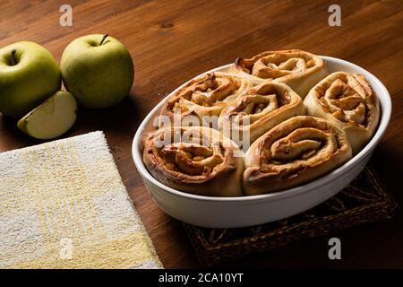 Petits pains à la cannelle de légumes faits avec de la pomme sur une planche de bois. Banque D'Images