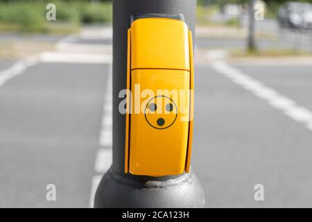 bouton jaune pour les personnes aveugles, handicapées ou handicapées aux feux de signalisation pour obtenir un signal sonore lorsque le feu de signalisation est vert pour traverser la rue Banque D'Images