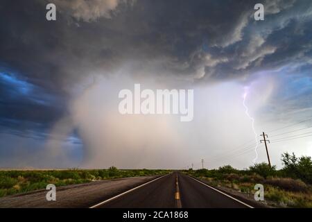 Route menant à une puissante tempête de mousson avec des nuages spectaculaires, de fortes pluies et des éclairs au-dessus de la plage Willcox dans le sud-est de l'Arizona Banque D'Images