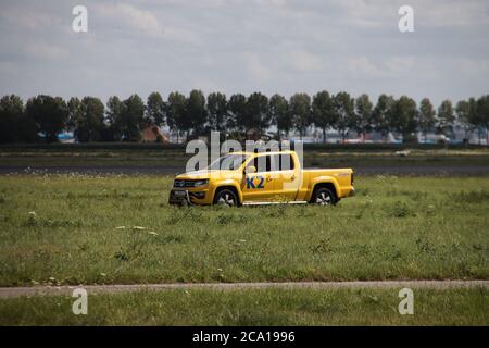 L'avion part de Polderbaan depuis l'aéroport d'Amsterdam Schiphol. Le véhicule de contrôle des oiseaux K2 prend soin des oiseaux indésirables Banque D'Images