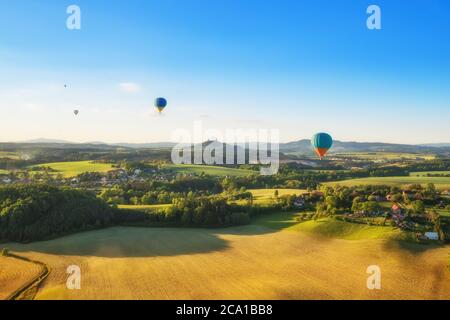 Groupe de ballons à air chaud volant au-dessus de la campagne rurale de la république tchèque, Europe. Voyage aérien et transport, magnifique paysage de la nature tourné en avant Banque D'Images