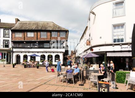 Les gens assis à l'extérieur d'un café dans la place du marché du centre-ville de Carlisle, Cumbria, Angleterre, Royaume-Uni Banque D'Images