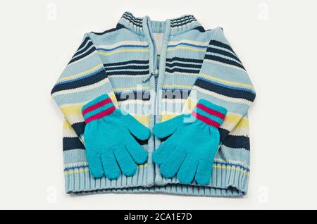 Ensemble de vêtements tricotés pour enfants composés d'un chandail et de gants isolés sur un fond blanc Banque D'Images