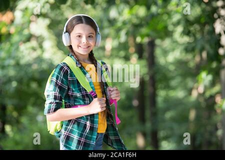 Fille scout mignon braides porter des vêtements à carreaux nature fond, concept de randonnée d'été. Banque D'Images