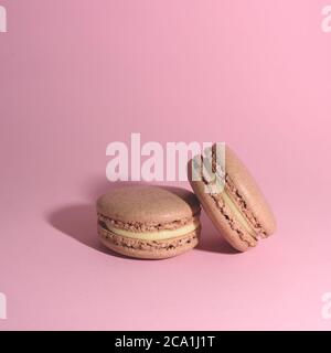 Deux délicieux macarons français sur fond lumineux. Macarons colorés. Vue avant. Banque D'Images