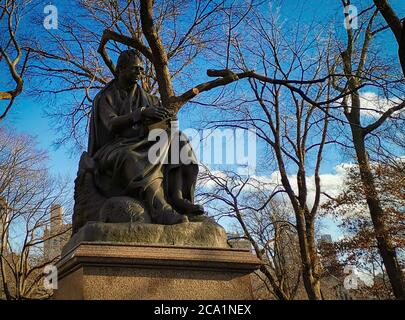 Statue de Walter Scott (par John Steell) dans Central Park New York vue sur la lumière du jour avec arbres, gratte-ciel et nuages dans le ciel Banque D'Images