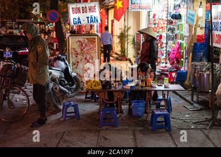 Hanoï / Vietnam - 21 janvier 2020: Femme asiatique vietnamienne mangeant sur table dans la rue près de la rue restaurant de nourriture Banque D'Images