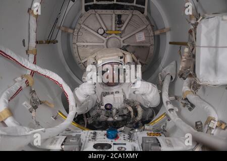 L'astronaute et commandant de l'expédition 63 de la NASA, Chris Cassidy, remet un pouce de l'intérieur de la partie verrouillée de l'équipage de l'écluse Quest après une sortie de six heures avec l'astronaute Bob Behnken pour échanger une batterie au nickel-hydrogène vieillissante contre une nouvelle batterie au lithium-ion à l'extérieur de la Station spatiale internationale le 1er juillet, 2020 dans Earth Orbit. Banque D'Images