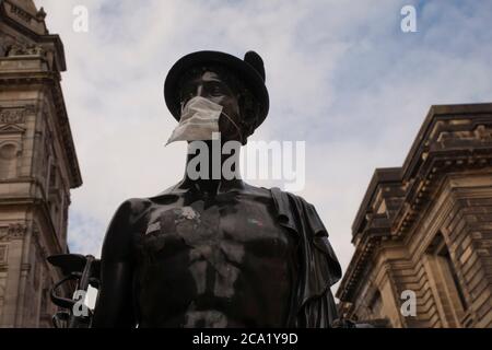 La statue de la Mercurial dans la rue Glasgow a été transformée en symbole du coronavirus (Covid 19) en portant un masque protecteur. Banque D'Images