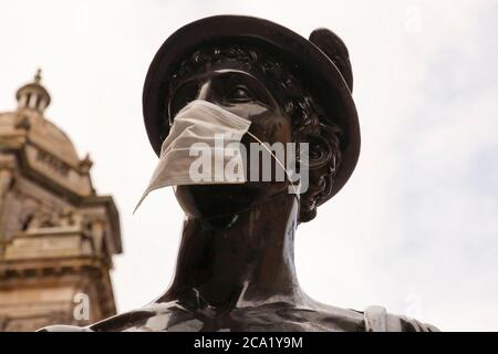 La statue de la Mercurial dans la rue Glasgow a été transformée en symbole du coronavirus (Covid 19) en portant un masque protecteur. Banque D'Images