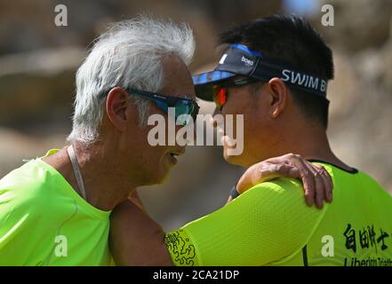 (200804) -- YINCHUAN, le 4 août 2020 (Xinhua) -- photo prise le 26 juillet 2020 montre Gu Dawo (L), un passionné de sports d'endurance, qui s'étire avec son coéquipier du club de triathlon après une course à Yinchuan, dans la région autonome de Ningxia hui, dans le nord-ouest de la Chine. Gu Dawo, grand-père chinois de 75 ans, a terminé cette année le marathon international de Xiamen avec un temps remarquable de 4 heures, 23 minutes et 45 secondes, ce qui a étonné de nombreux coureurs plus jeunes. Ayant commencé à s'entraîner pour le marathon à l'âge de 69 ans, Gu a terminé son premier semi-marathon en 2013. Depuis, Gu a commencé à courir un marathon numérotant Banque D'Images