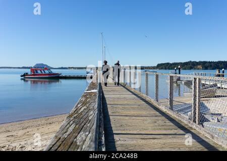 Tauranga Nouvelle-Zélande - juillet 27 2020; front de mer d'Omokoroa avec deux personnes marchant sur la jetée. Banque D'Images