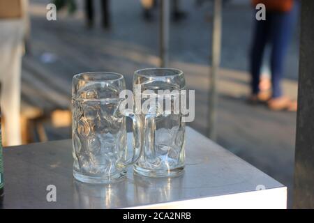Vider la tasse à bière sur la table de jardin en métal. Banque D'Images