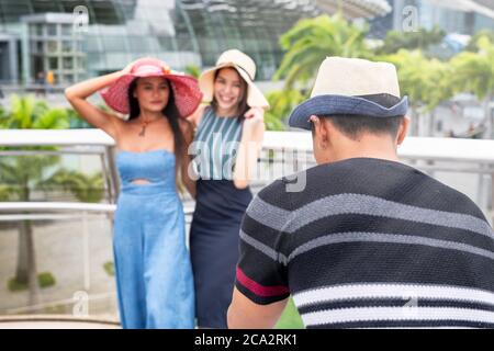 Homme asiatique prenant des photos de deux femmes asiatiques. Concept de voyage et de vacances. Banque D'Images
