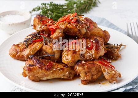 Ailes de poulet au barbecue. Chiken cuit au four sur plaque. Cuisine coréenne chaude. Vue latérale, gros plan Banque D'Images
