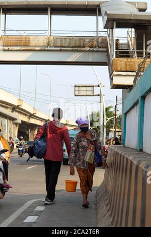 Jakarta / Indonésie - 25 juillet 2020. Vendeurs de plantes médicinales qui marchent autour de tenir le jamu et portant un seau Banque D'Images