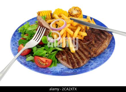 Steak d'aloyau grillé et repas de frites avec salade fraîche et épis de maïs doux isolés sur fond blanc Banque D'Images