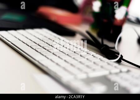 un clavier d'ordinateur gris moderne avec des touches blanches sur une table de bureau. Faible profondeur de champ. Profession et travail de bureau Banque D'Images