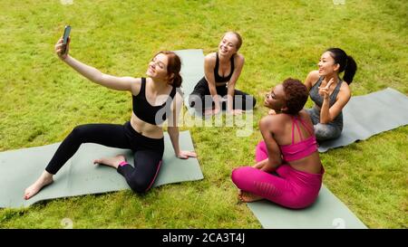 Groupe de belles filles sportives prenant le selfie avant leur pratique de yoga dans la nature Banque D'Images