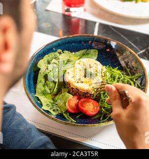 Homme mangeant une salade savoureuse vue de dessus Banque D'Images