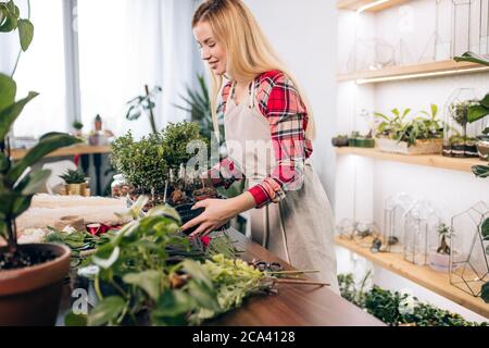 belle femme caucasienne qui aime la flore et les plantes, aimez travailler dans le magasin de fleurs ou avoir son propre magasin de fleurs. Banque D'Images