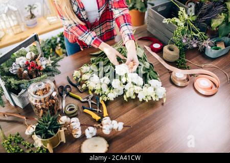 Propriétaire de petite entreprise et belle femme fleuriste préparant un bouquet de fleurs blanches, aimez travailler avec des plantes et des fleurs. Botanique, concept de plantes Banque D'Images