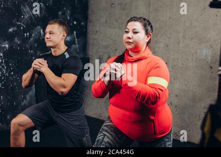 femme plumeuse avec un homme sportif faisant des exercices dans le centre sportif. gros plan vue latérale photo. intérêt, style de vie Banque D'Images