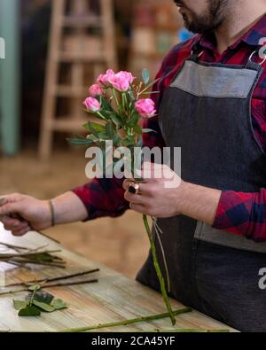 Fleuriste homme faisant un bouquet de fleurs au magasin Banque D'Images