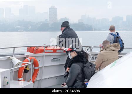 Une femme asiatique portant un masque et d'autres personnes ne se portant pas sur l'arc d'un ferry pour chats de la rivière Sydney dans le port de Sydney en Australie Banque D'Images