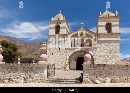 Maca, Pérou - 26 septembre 2018 : femme en vêtements traditionnels devant l'église de Santa Ana, dans le petit village de Maca, près du canyon de Colca, Pérou Banque D'Images