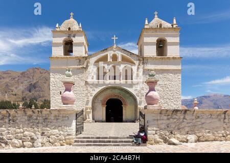 Maca, Pérou - 26 septembre 2018 : femme en vêtements traditionnels devant l'église de Santa Ana, dans le petit village de Maca, près du canyon de Colca, Pérou Banque D'Images