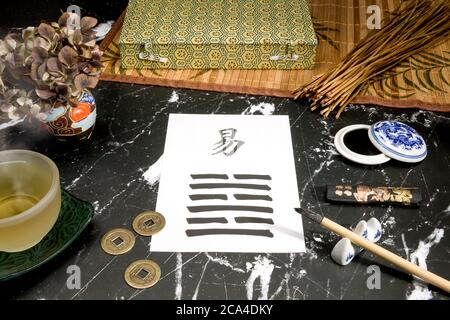 Gros plan d'un arrangement I Ching avec le 63ème hexagramme (après la complition/Chi Chi) écrit avec une brosse à encre chinoise sur papier de riz. Il y en a aussi Banque D'Images